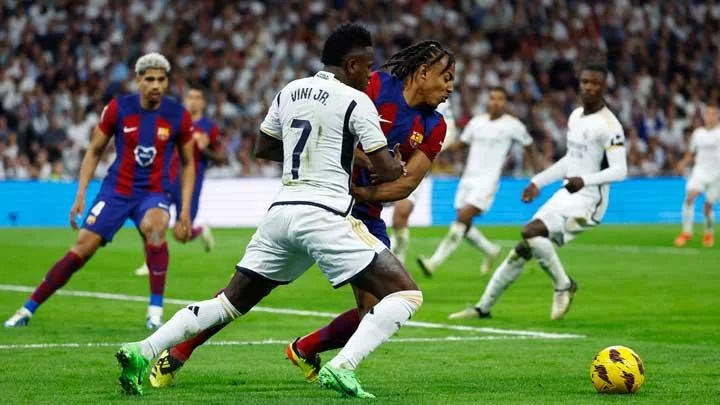 Pemain Real Madrid Vinicius Junior berduel dengan pemain Barcelona Jules Kounde dalam pertandingan Liga Spanyol di Santiago Bernabeu, Madrid, 22 April 2024. REUTERS/Susana Vera