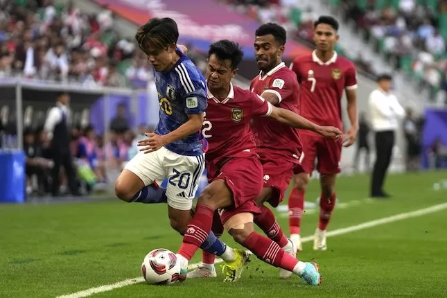 Pratama Arhan menekel Takefusa Kubo di laga Jepang vs Indonesia di matchday 3 Grup D Piala Asia 2023 di Al Thumama Stadium, Rabu (24/01/2024) malam WIB. (c) AP Photo/Thanassis Stavrakis