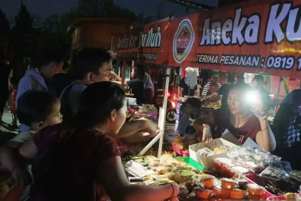 Pedagang melayani pembeli menggunakan penerangan senter ponsel saat terjadi gangguan pasokan listrik di Denpasar, Bali, Jumat (2/5/2025). ANTARA FOTO/Nyoman Hendra Wibowo/Spt.