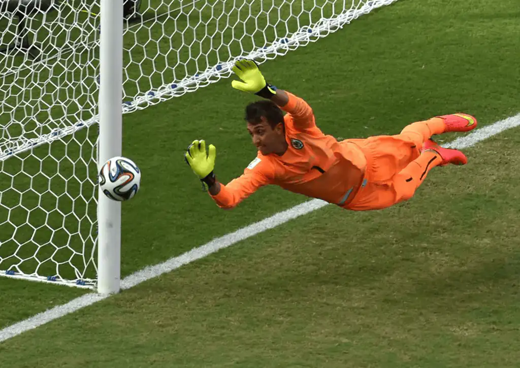 Kiper Uruguay Fernando Muslera melakukan diving saat pertandingan sepak bola Grup D antara Italia dan Uruguay di Dunas Arena di Natal selama Piala Dunia FIFA 2014 pada 24 Juni 2014. Uruguay menang 1-0. (c) FIFA/YASUYOSHI CHIBA/AFP via Getty Images