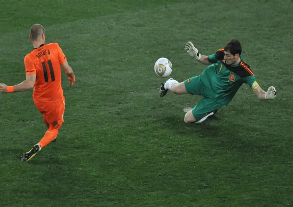 Kiper Spanyol Iker Casillas (kanan) melakukan penyelamatan dengan kakinya dari tendangan striker Belanda Arjen Robben selama final Piala Dunia sepak bola 2010 di stadion Soccer City di Soweto, pinggiran Johannesburg pada 11 Juli 2010. (c) FIFA/ROBERTO SCHMIDT/AFP via Getty Images